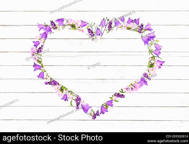 Violet lavender, bluebells and rose cuckooflower arranged in a heart frame