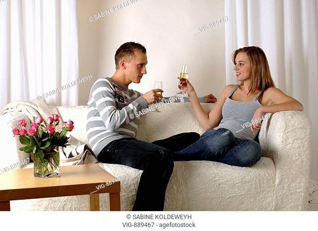 Young couple sitting on a sofa and drinking sparkling wine. - 30/06/2008