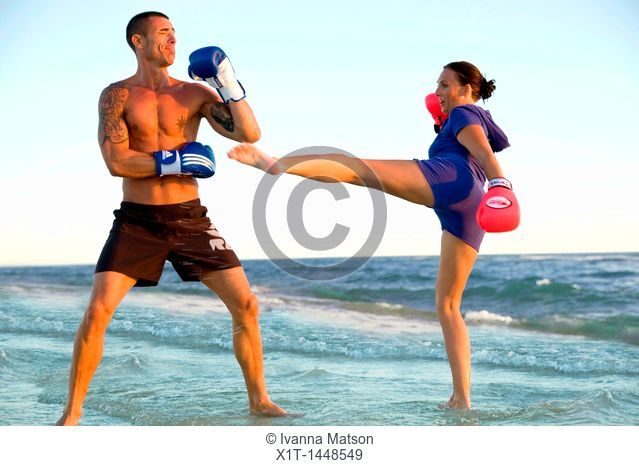 Couple kickboxing on the beach
