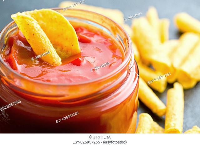 rolled nacho chips and salsa dip on kitchen table