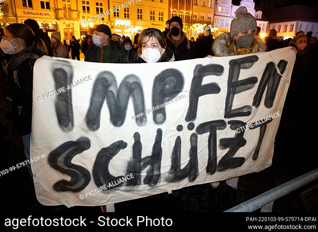 03 January 2022, Mecklenburg-Western Pomerania, Greifswald: Demonstrators display a poster with the slogan ""Vaccination protects""