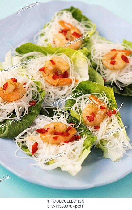 Mini glass noodle nests with spicy prawns on lettuce leaves