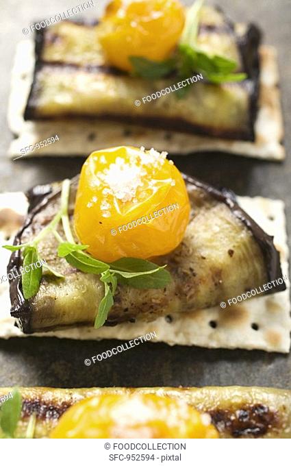 Crackers with grilled aubergines and cherry tomatoes