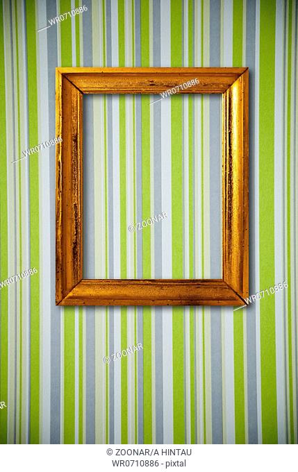 Gold frame on striped vintage wallpaper background