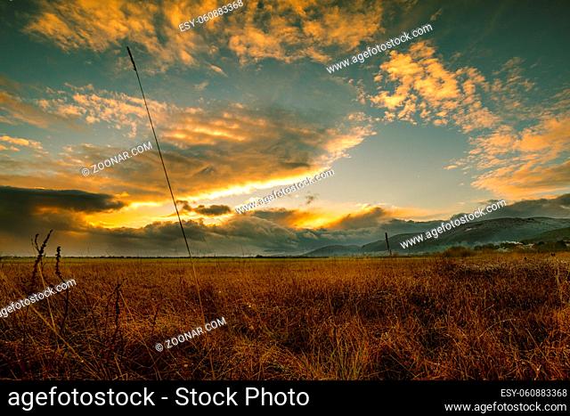Sunset in autumn over a field in austria with hills in the background