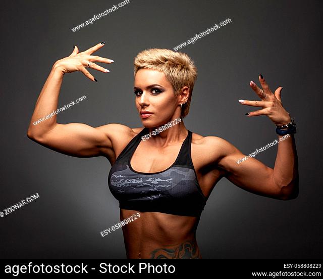 Portrait of a beautiful strong woman in sportswear with a short haircut and make-up. The concept of feminism, willpower, sports lifestyle