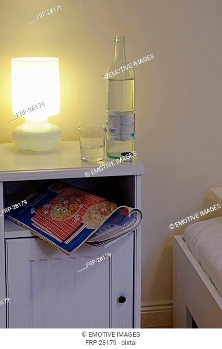 Bottle and glass of water on bedside table