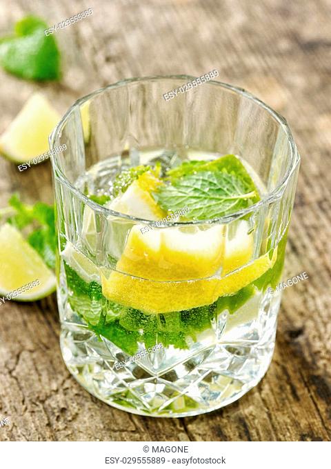 carbonated water with lemon and mint in a glass on wooden table