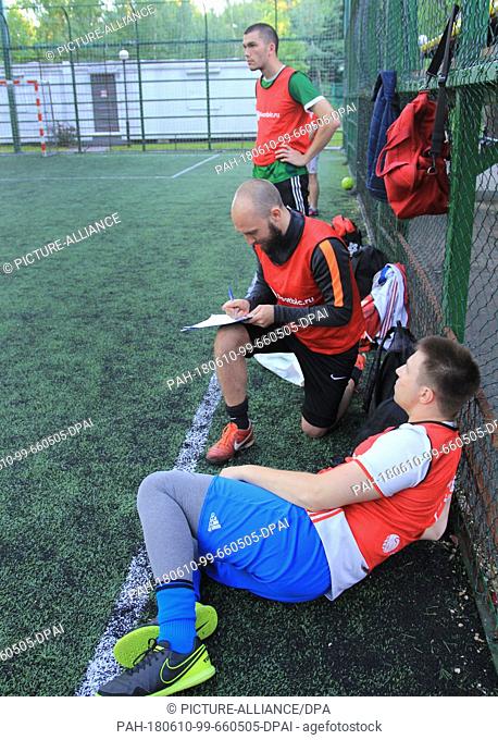 29 May 2018, Russia, Moskow: Alexey Popov (c), founder of the business Footbic, takes notes during a soccer game at Sokolniki Park