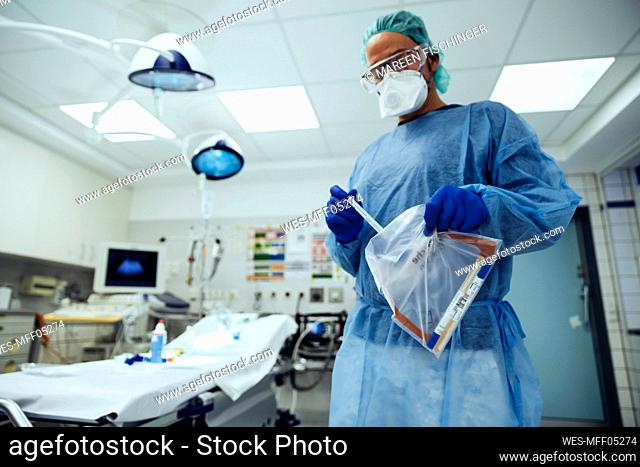 Emergeny doctor putting a swab into a plastic bag in hospital