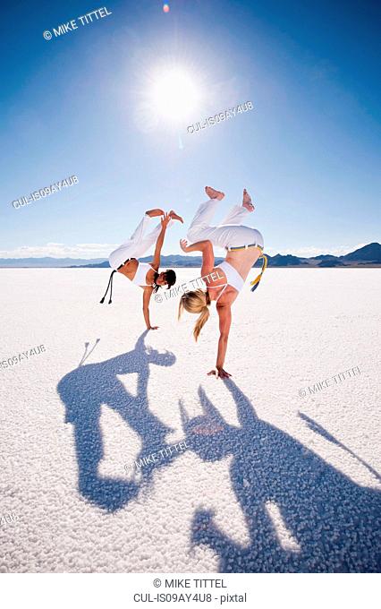 Two women performing capoeira on Bonneville Salt Flats, Utah, USA