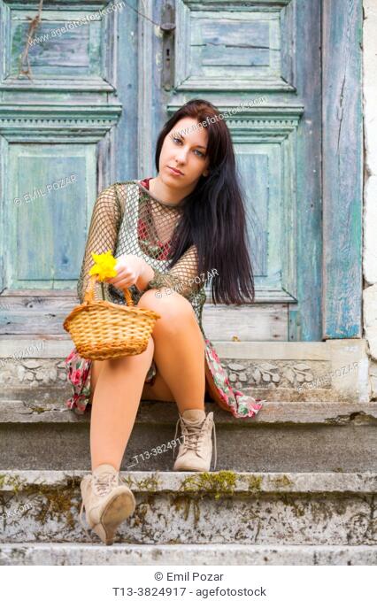Country-girl sitting on porch with flowers in basket
