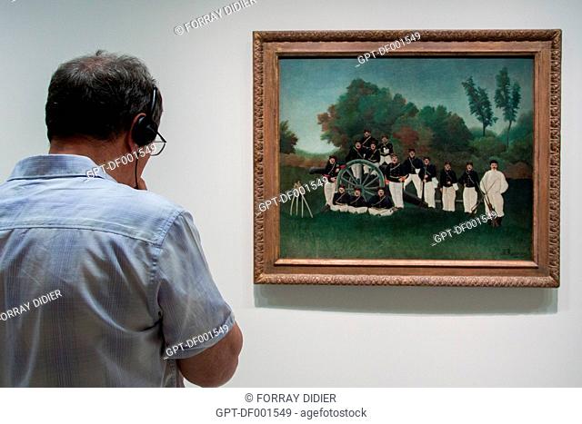 VISITOR LOOKING AT THE PAINTING BY HENRI ROUSSEAU ENTITLED THE ARTILLERYMEN AT THE GUGGENHEIM MUSEUM OF NEW YORK, THE UPPER EAST SIDE, MANHATTAN, NEW YORK CITY
