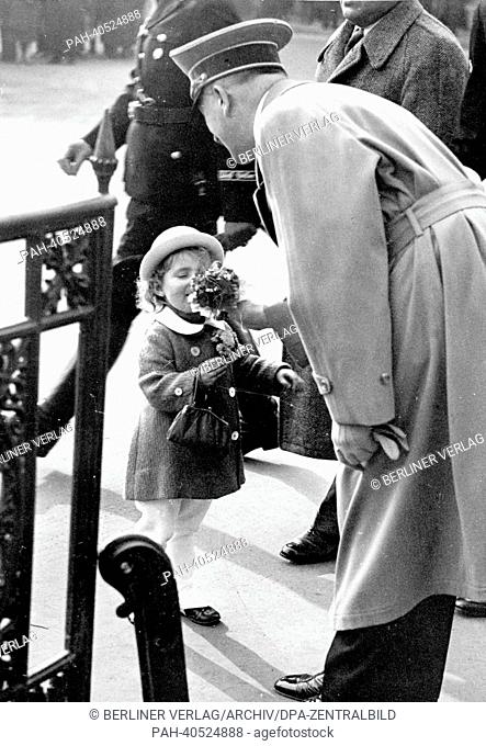 The image from the Nazi Propaganda! shows Adolf Hitler receiving flowers from a little girl on his way to a reception at the Ministry of Public Enlightenment...