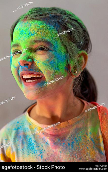 Close up of a girl celebrating Holi with colors on her face