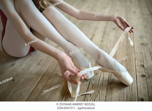 Professional ballerina putting on her ballet shoes