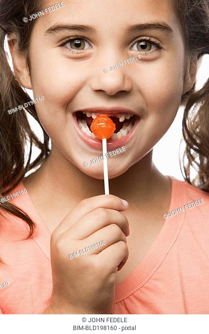 Mixed race girl eating lollipop