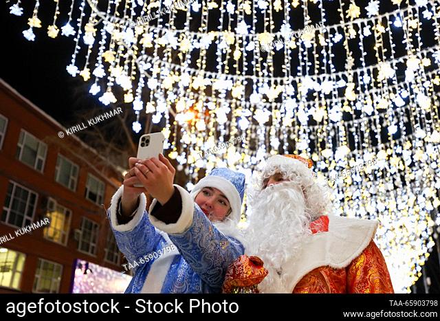 RUSSIA, NOVOSIBIRSK - DECEMBER 19, 2023: Father Frost and Snow Maiden (Russian Santa Claus and his granddaughter) take a selfie in Lenina Square