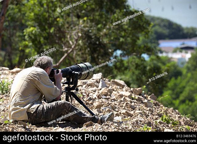 Photographer with long telelens, paparazzi