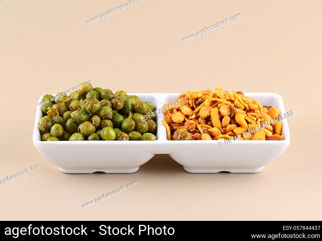 Indian snack: Mixture and Spiced fried green peas {chatpata matar} in white plate