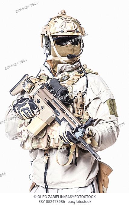 Army soldier in Protective Combat Uniform holding Special Operations Forces Combat Assault Rifle. Mag recovery pouch, chest rig, military boots