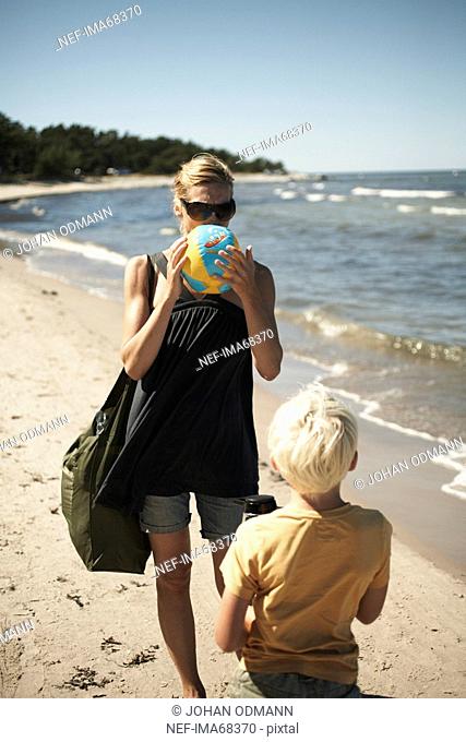Mother inflating beach ball Gotland Sweden