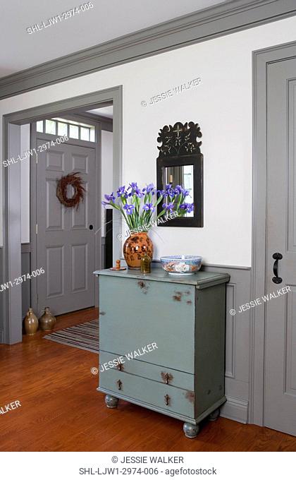 LIVING ROOM DETAILS: Pale blue painted cabinet, vase of iris, carved mirror, greay painted trim, simple lines