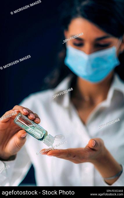 Covid-19 coronavirus outbreak prevention. Young woman disinfecting her hands, using hand sanitizer gel
