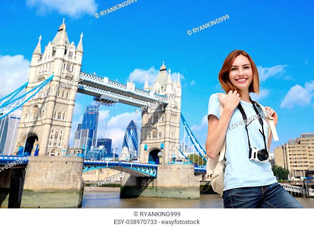 Happy woman travel in London with tower bridge, and smile to you, caucasian beauty