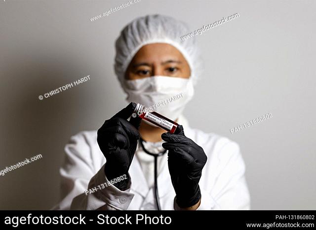 A virologist poses with a corona blood sample (Symbolto with Model) | usage worldwide. - Nuremberg/Bayern/Deutschland