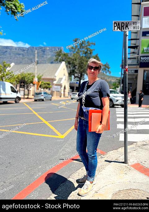 PRODUCTION - 03 November 2022, South Africa, Kapstadt: Christina Leitner is standing at an intersection in Cape Town with her laptop