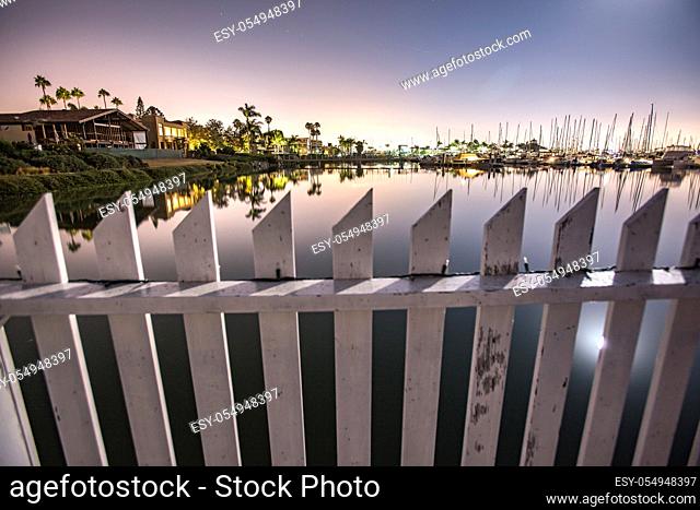 A white fence spans the water in Point Loma