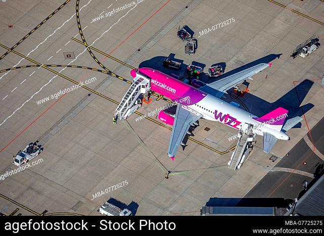Aerial picture, WIZZ air, travel jet in the loading position, luggage car, international airport of Dortmund, DTM, overview over runway 06 and approach, Apron