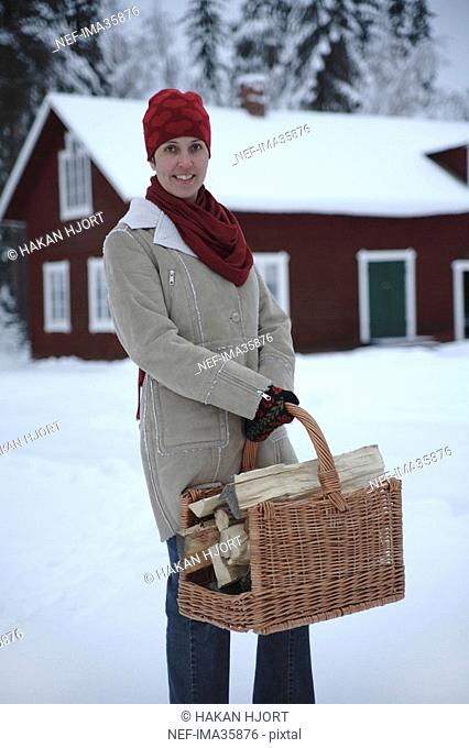 A woman with firewood in a basket