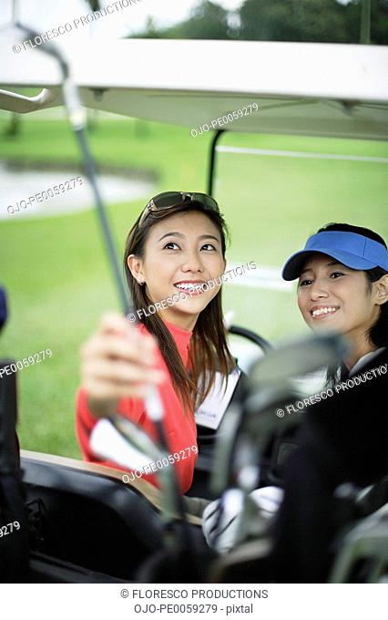 Two women in a golf cart
