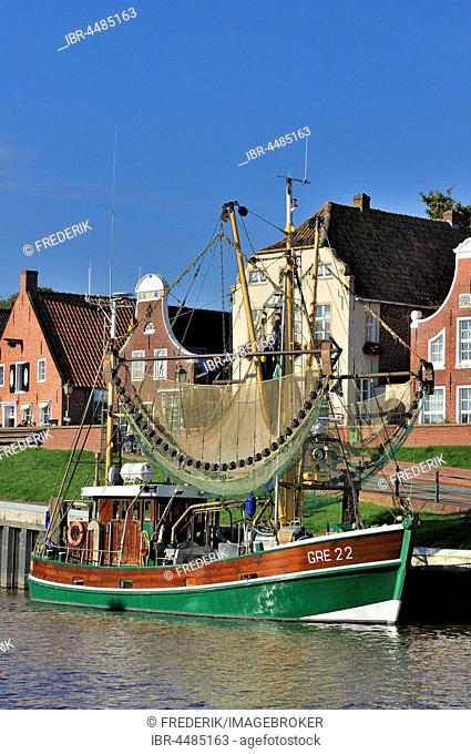 Crab cutters in the harbor, in front of historical buildings, Greetsiel, Lower Saxony, Germany