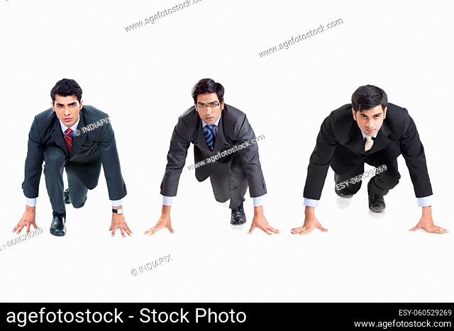 A group of male corporate employees in formal business suit about to run a race