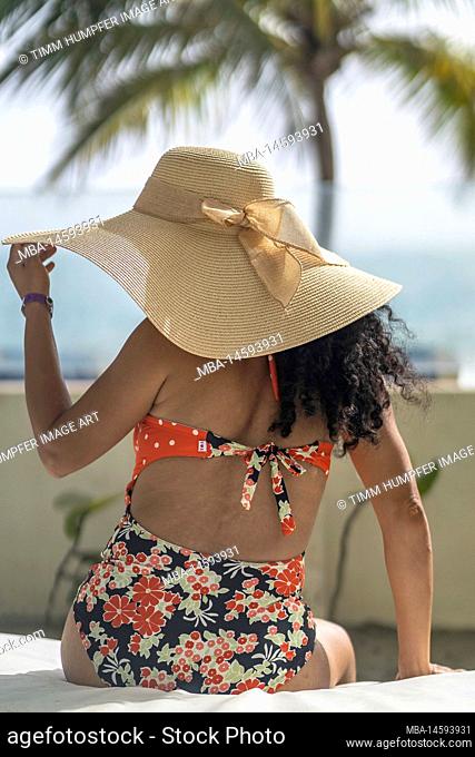 North America, Caribbean, Greater Antilles, Hispaniola Island, Dominican Republic, Puerto Plata Province, Cabarete, Attractive woman sitting on beach lounger