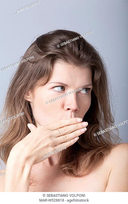 woman covers her mouth with her hand