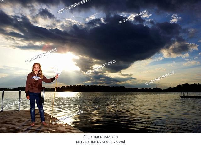 Girl with a bag net on a jetty, Sweden