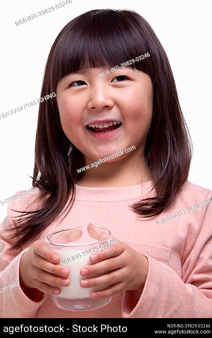 Portrait of girl drinking a glass of milk with a milk moustache