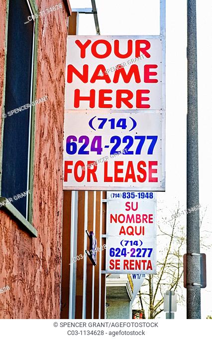 A pair of real estate rental signs in the 'barrio' Hispanic neighborhood of Santa Ana, California offer English and Spanish languagage versions of the same...