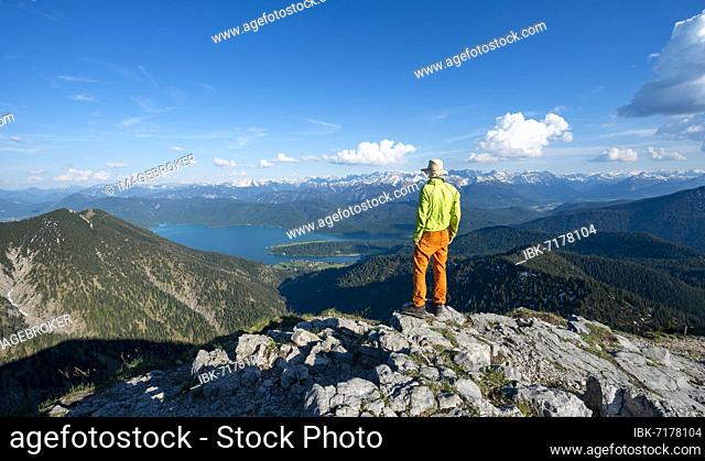 Hiker at the summit of Heimgarten, view into the distance, Karwendel Mountains in the background, ridge walk Herzogstand Heimgarten, Upper Bavaria, Bavaria
