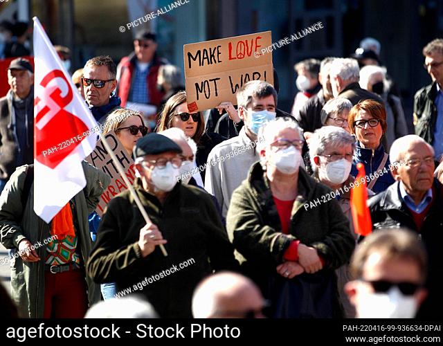 16 April 2022, North Rhine-Westphalia, Duisburg: At the start of the Easter March Rhine/Ruhr, a participant demands ""Make Love not War"" on a poster