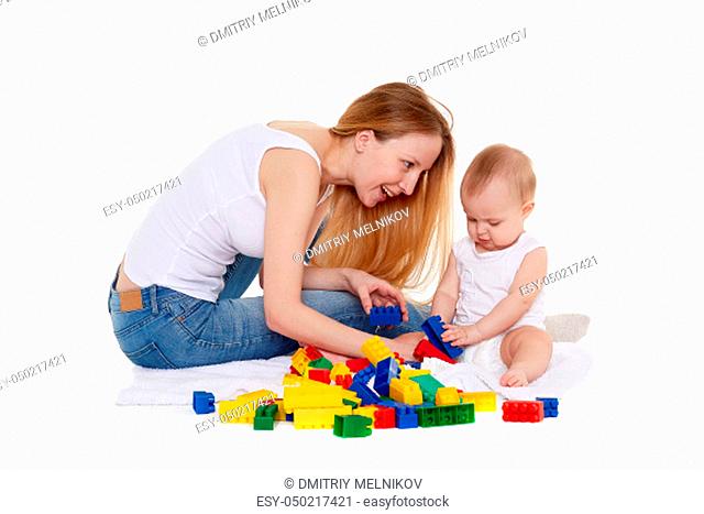 Young woman and her daughter are playing with developing toy on a white background. Happy family. Eight months