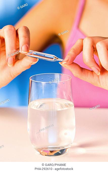 Woman holding glass ampoules of trace elements