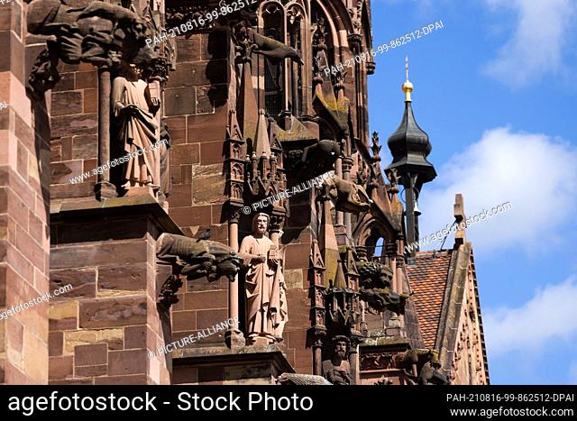 16 August 2021, Baden-Wuerttemberg, Freiburg: Stone figures and gargoyles can be seen on the southern façade of Freiburg Cathedral