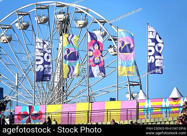 PRODUCTION - 02 September 2023, Bavaria, Munich: A Ferris wheel and flags on the ""Superbloom"" in Munich. Around 50, 000 people celebrated on the grounds of...