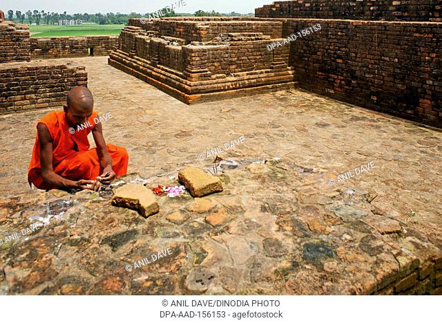 Monk praying at Buddhist site ; Sarasvati ; Uttar Pradesh ; India