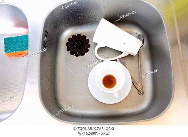Dishwashing. White dishes in the kitchen sink